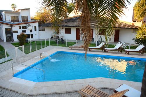 - une piscine avec des chaises et une maison dans l'établissement HOTEL MIRAMAR, à Miramar