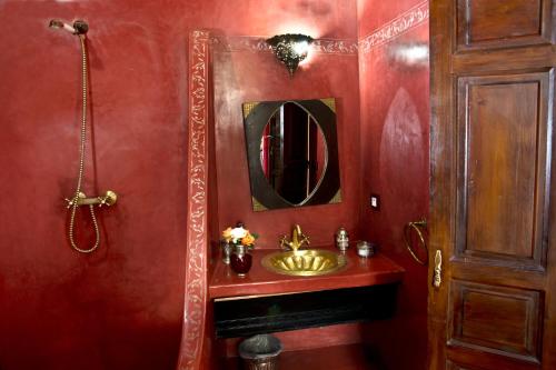 a bathroom with a gold sink and a mirror at Riad Al Loune in Marrakech