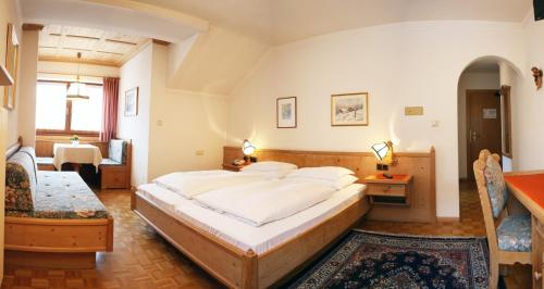 sypialnia z dużym łóżkiem w pokoju w obiekcie Hotel Dolomiti Madonna w mieście Ortisei