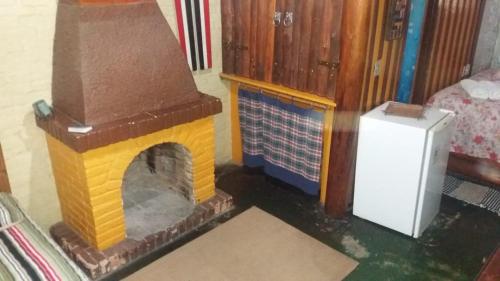 a toy house with a fireplace in a room at A Casinha Pequenina in Monte Verde
