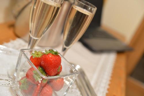 two champagne glasses with strawberries on a table at Hotel Garnì COSTANZA in Livigno
