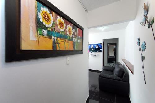 a living room with a couch and a painting on the wall at cozy apartment excellent location, air conditioning in Cali