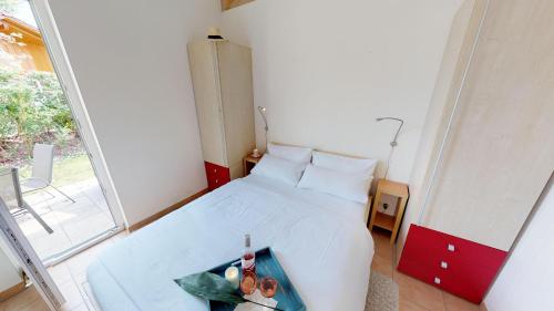 ペルツァーハケンにあるFeriendorf Südstrand Haus 01の小さなベッドルーム(白いベッド1台、窓付)
