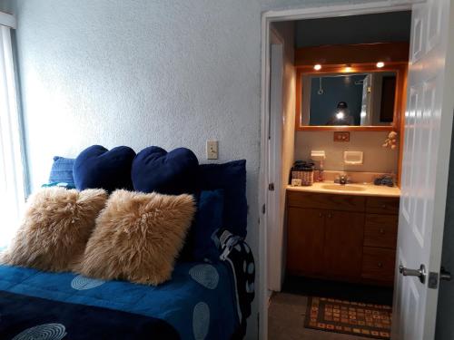 a bedroom with a blue bed with a mirror and a sink at Blue House in Ensenada