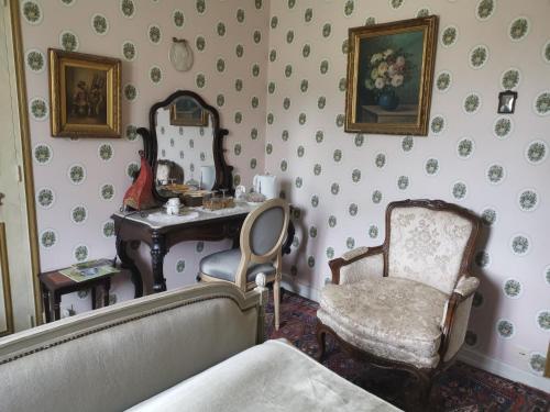 a bedroom with a vanity and a chair and a mirror at Le Kino Panorama in Vic-sur-Cère