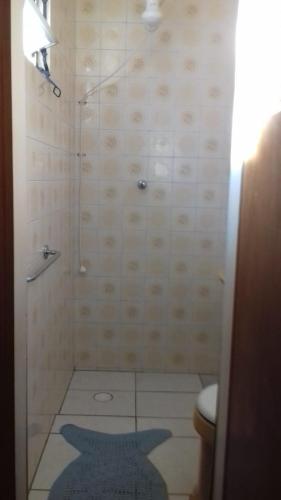 a bathroom with a shower with a toilet and a rug at Casa 183 in Itajaí
