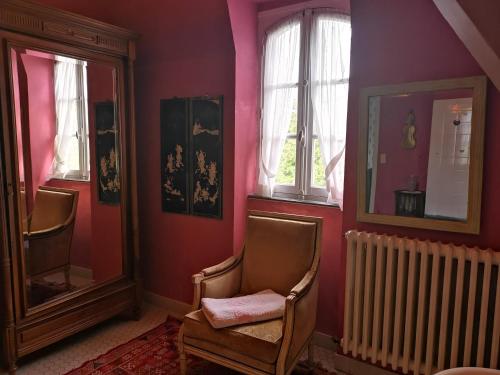 a room with a chair and a mirror and a radiator at Le Kino Panorama in Vic-sur-Cère