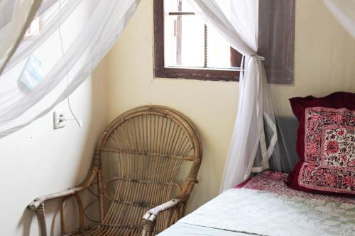 a bedroom with a bed and a window and a chair at Harrys Oceanhouse 2 Pacitan in Pacitan