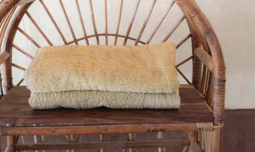 a pillow sitting on top of a wooden chair at Harrys Oceanhouse 2 Pacitan in Pacitan