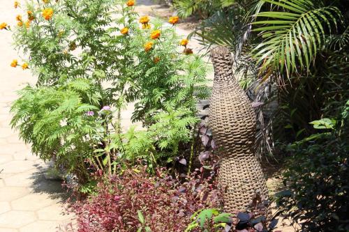 a garden with a statue in the middle of some plants at Harrys Oceanhouse 2 Pacitan in Pacitan