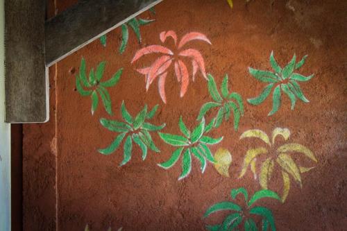 a wall with green and red flowers painted on it at Harrys Oceanhouse 2 Pacitan in Pacitan