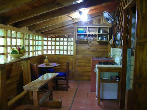 a kitchen with wooden walls and a table and a stove at The Blue lagoon Surf Beach House in Playa Avellana