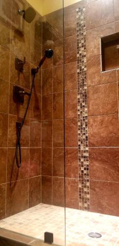 a shower with a shower head in a bathroom at Chateau du Pikes Peak, a Tuscany Retreat in Colorado Springs