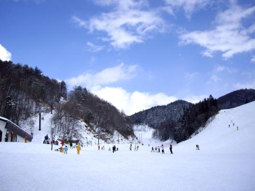 a group of people skiing down a snow covered slope at BEYOND HOTEL Takayama 2nd in Takayama