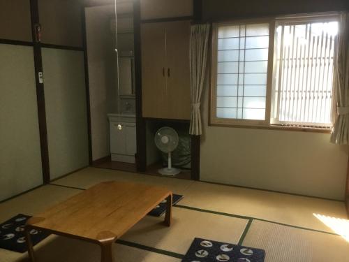 a living room with a wooden table and a window at Ryokan Sarashinaya in Kiso