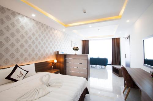 a hotel room with a bed and a desk and a desk at Phung Hung Boutique Hotel in Phu Quoc