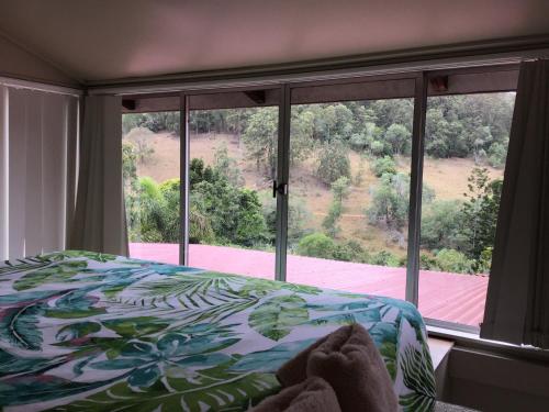 a bedroom with a bed and a large window at Rossmount Rural Retreat in Goomboorian