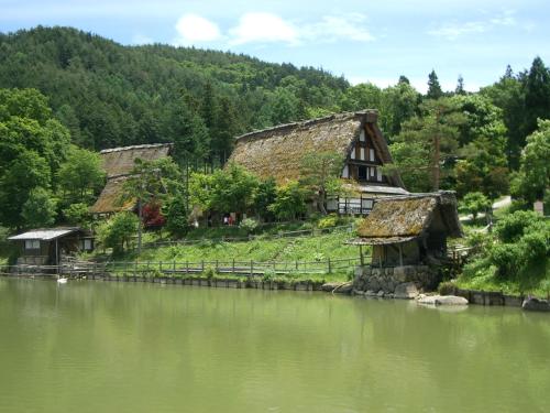 a group of buildings on a hill next to a river at BEYOND HOTEL Takayama 2nd in Takayama