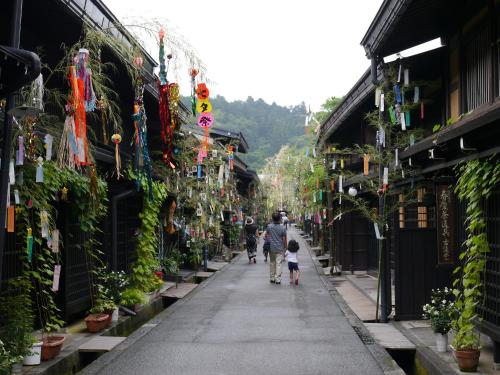a man and a child walking down a street at BEYOND HOTEL Takayama 2nd in Takayama