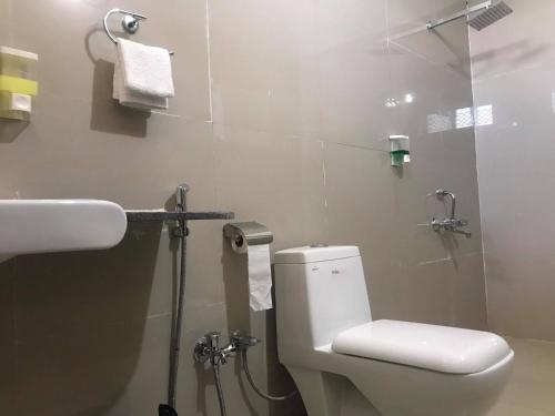 a bathroom with a toilet and a shower and a sink at Deogarh Hills A Village Experience Property in Kaunthal