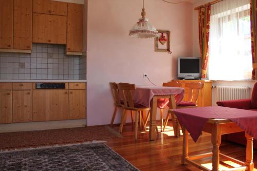 a kitchen with a table and a dining room at Appartementhaus Lechnerhof in Brunico