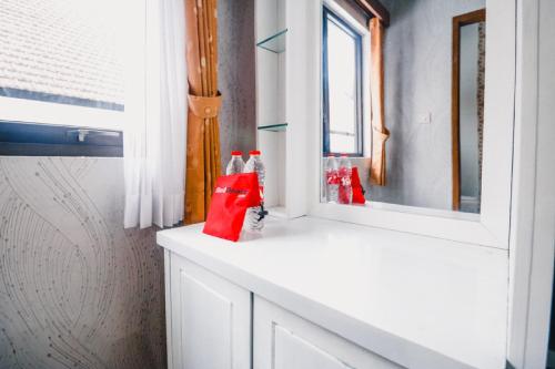 a bathroom with two bags on a counter next to a mirror at RedDoorz near Taman Rekreasi Selecta in Malang