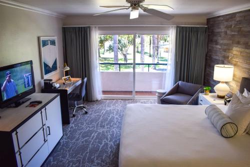 a hotel room with a bed and a desk and a window at Beachside Inn in Santa Barbara