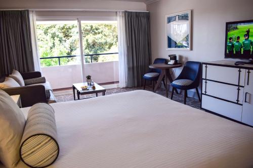 a hotel room with a large bed and a tv at Beachside Inn in Santa Barbara