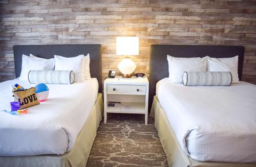 a hotel room with two beds with white sheets at Beachside Inn in Santa Barbara