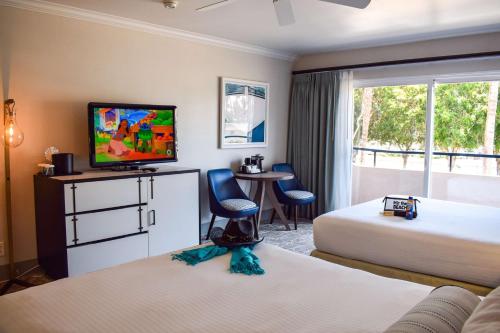 a hotel room with two beds and a flat screen tv at Beachside Inn in Santa Barbara
