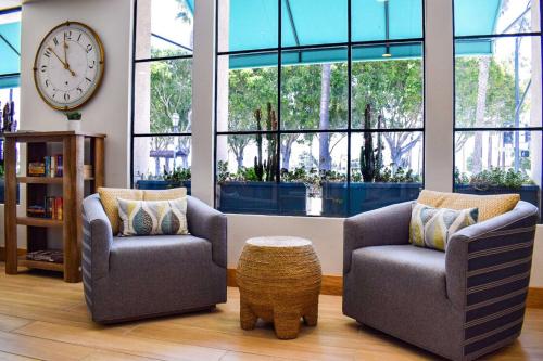 a living room with two chairs and a clock at Beachside Inn in Santa Barbara