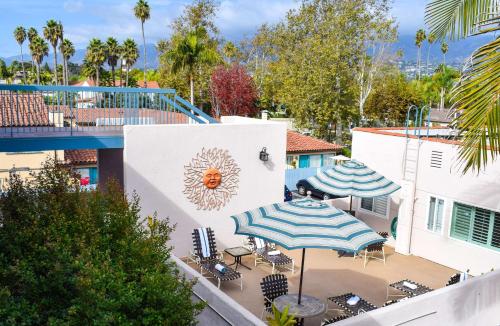 a patio with umbrellas and chairs and a pool at Beachside Inn in Santa Barbara