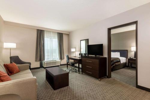 a hotel room with a bed and a desk with a mirror at Wingate by Wyndham Angola in Angola