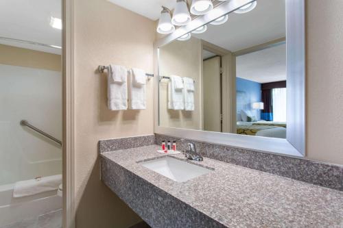 a bathroom with a sink and a mirror at Baymont by Wyndham Cheraw in Cheraw