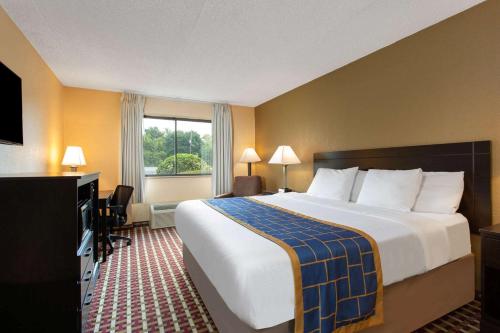 um quarto de hotel com uma cama grande e uma janela em Days Inn by Wyndham Hillsborough em Hillsborough