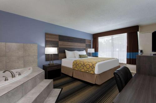 um quarto de hotel com uma cama e uma banheira em Baymont by Wyndham Cheraw em Cheraw