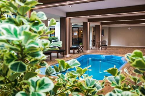 a pool in the middle of a house with plants at B Stay Hotel in Bangkok