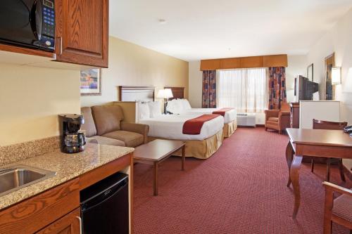um quarto de hotel com uma cama e uma sala de estar em Holiday Inn Express Hotel & Suites Tooele, an IHG Hotel em Tooele