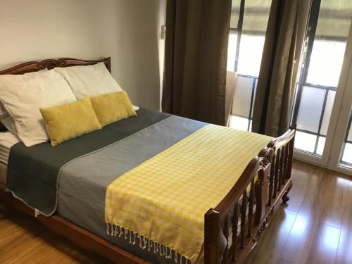 a bedroom with a bed with a yellow and gray blanket at Appartement de 80m2 au cœur de Perpignan in Perpignan