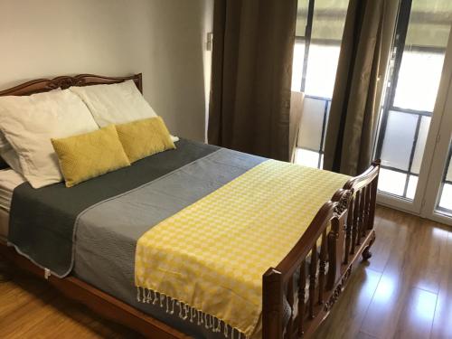 une chambre avec un lit avec une couverture jaune et grise dans l'établissement Appartement de 80m2 au cœur de Perpignan, à Perpignan