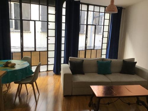 a living room with a couch and a table at Appartement de 80m2 au cœur de Perpignan in Perpignan