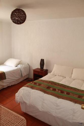 a bedroom with two beds and a table with a lamp at Hotel Velero Sur in Iquique