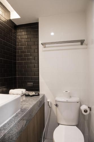 a bathroom with a white toilet and a sink at B Stay Hotel in Bangkok