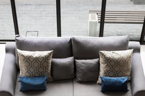 a couch with pillows on it in a room at B Stay Hotel in Bangkok
