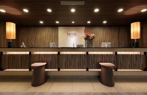 a lobby with a reception counter with stools at Keio Presso Inn Ikebukuro in Tokyo