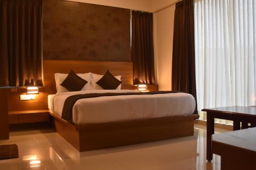 a bedroom with a large bed with two pillows at Heritage Inn in Mysore