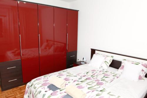 a bedroom with red cabinets and a bed at Apartman Malina in Karlovac
