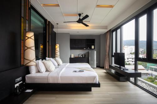 1 dormitorio con cama grande y ventana grande en De Chai Oriental Nimman - SHA Plus en Chiang Mai