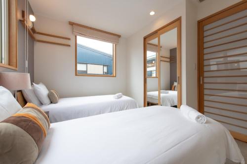 a bedroom with two beds and a window at Shinsetsu in Kutchan