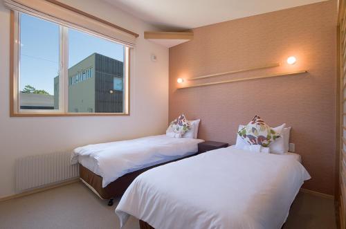 two beds in a room with a window at Shinsetsu in Kutchan